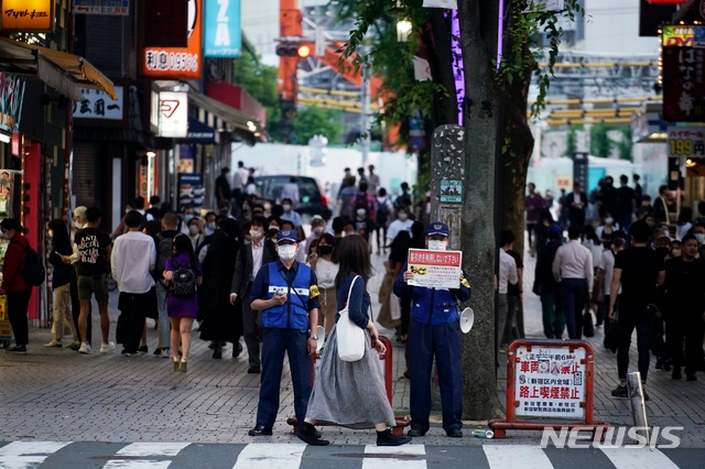 도쿄도 직원들이 지난 4일 신주쿠 가부키초 유흥가에서 호객행위 금지를 알리는 플래카드를 들고 있다.