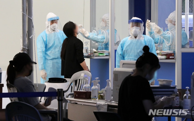 의료진들이 15일 오후 서울 송파구 보건소 선별진료소에서 신종 코로나바이러스 감염증(코로나19) 검체를 채취하고 있다.