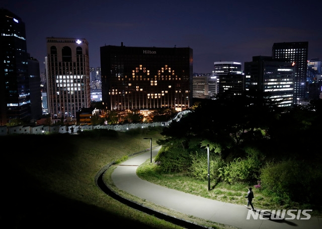 4월26일 촬영한 한국 서울의 밀레니엄 힐튼 호텔 모습. 신종 코로나바이러스 감염증(코로나19) 사태에서 응원 메시지를 보내기 위해 호텔 전면에 웃는 모습이 나타나도록 조명을 설정했다.