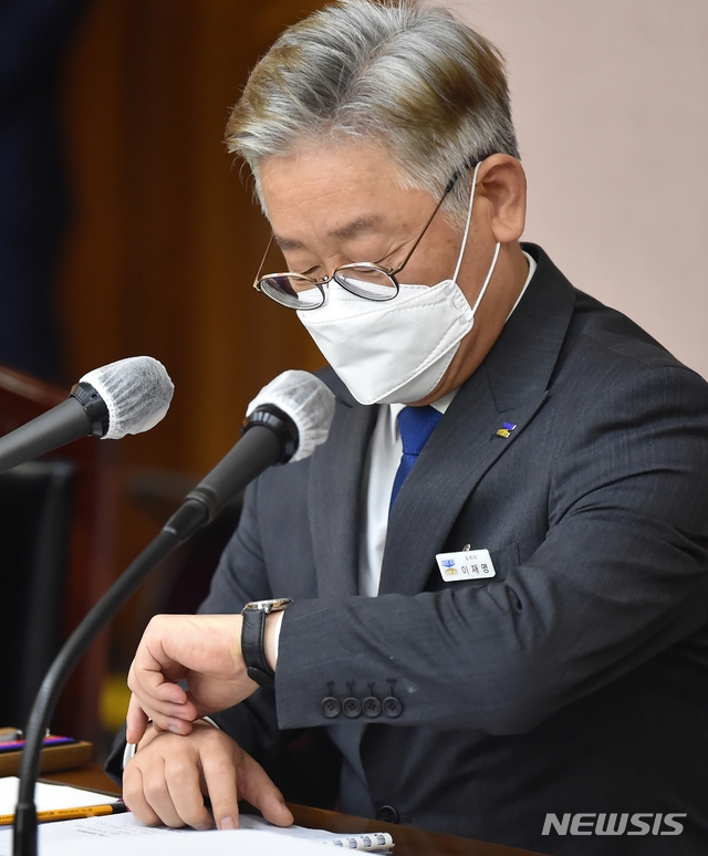 18일 오후 이재명 경기도지사가 경기 수원시 경기도청에서 열린 6월 확대간부회의에 참석해 시계를 보고 있다.