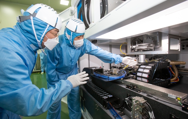 삼성전자 직원(좌)과 이오테크닉스 직원(우)이 양사가 공동 개발한 반도체 레이저 설비를 함께 살펴보고 있다. (사진=삼성전자) 