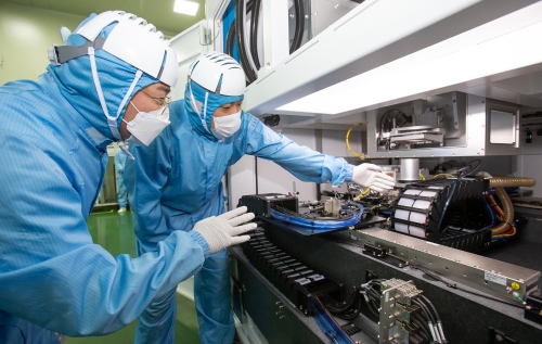 삼성전자 직원(좌)과 이오테크닉스 직원(우)이 양사가 공동 개발한 반도체 레이저 설비를 함께 살펴보고 있다. / 사진제공 = 삼성전자