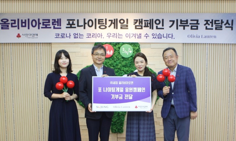 세정 박이라 사장(오른쪽 두 번 째)과 이진성 올리비아로렌 사업본부장(오른쪽)이 서울 사랑의열매 김용희 사무처장(왼쪽 두 번 째)과 기부금 전달식 기념촬영을 하고 있다.
