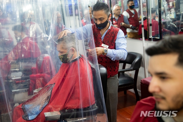 미국 신종 코로나바이러스 감염증(코로나19) 집중 발생지인 뉴욕주 뉴욕시가 22일 2단계 경제 재개에 돌입했다. 이에 따라 약 석달 만에 식당 야외 공간 식사 및 미용실 운영 등이 허용됐다. 사진은 이날 문을 연 뉴욕의 한 미용실 모습.