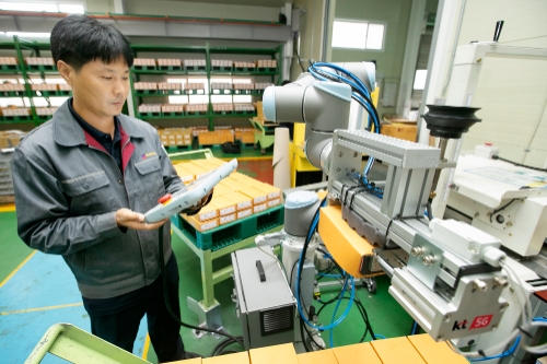 충북 제천에 있는 박원 공장에서 생산직 근로자가 KT 5G 스마트팩토리 코봇과 함께 작업하고 있다. /  사진제공 = KT