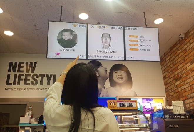 (사진=이마트) 이마트24 매장에서 고객이 디지털사이니지를 통해 실종아동의 정보를 보고 있다