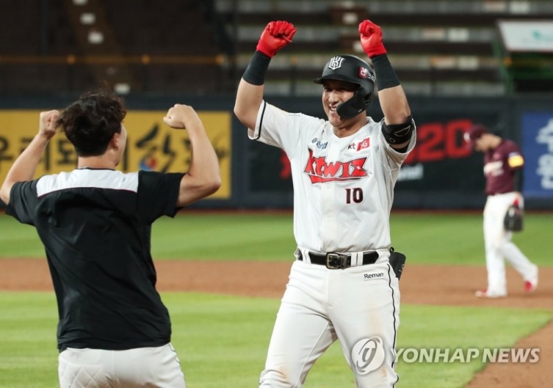 KT 황재균이 끝내기 안타를 날린뒤 동료의 환영을 받고 있다.