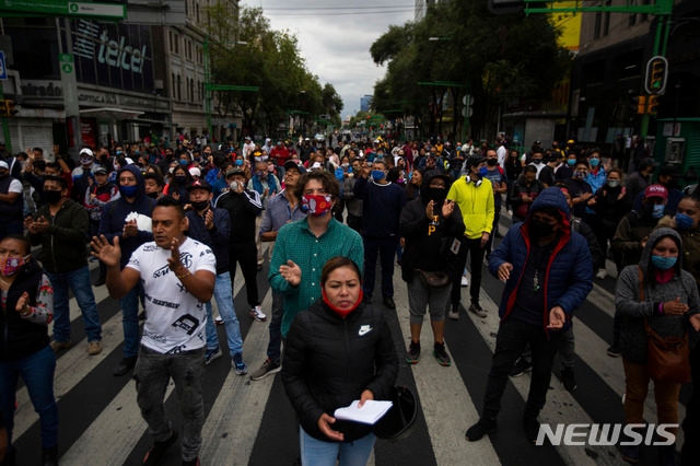 지난 6월11일(현지시간) 멕시코 수도 멕시코시티에서 노점상들이 경제활동 재개를 요구하는 시위에 참여해 구호를 외치며 행진하고 있다. 이들은 신종 코로나바이러스 감염증(코로나19) 확산 억제를 위한 제재로 지난 3월부터 생계를 유지하기 어려워져 경제 활동 재개를 요구하는 시위를 벌이고 있다. 멕시코의 4월 경제활동은 1년 전과 비교해 30% 가까이 급감한 것으로 나타났다.