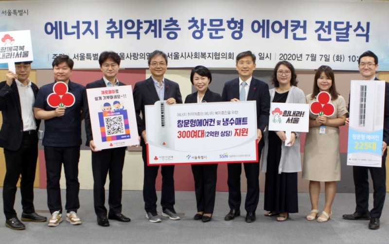 김선순 복지정책실장(가운데), 김현훈 서울시사회복지협의회 회장(가운데 오른쪽),김용희 서울사랑의열매 사무처장(가운데 왼쪽)이 임직원들과 에너지취약계층 창문형에어컨 전달식 사진을 찍고 있다.