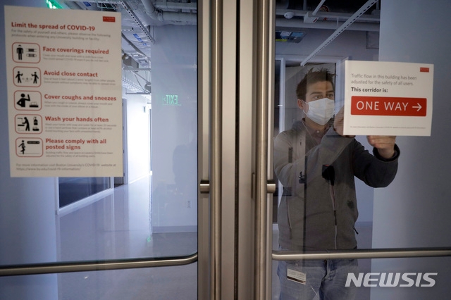 지난달 21일 미국 보스턴 대학교의 운영위원장이 교내 출입문에 안내문을 부착하고 있다. 미 국토안보부 산하 이민세관단속국(ICE)은 전날인 6일 홈페이지에 '학생 및 교환방문자 프로그램(SEVP)' 규정을 개정한다며 "2020년 가을학기의 모든 수업을 온라인으로 듣는 비이민자 유학생의 비자를 취소하고, 신규 비자 발급을 중단하겠다"고 밝혔다.