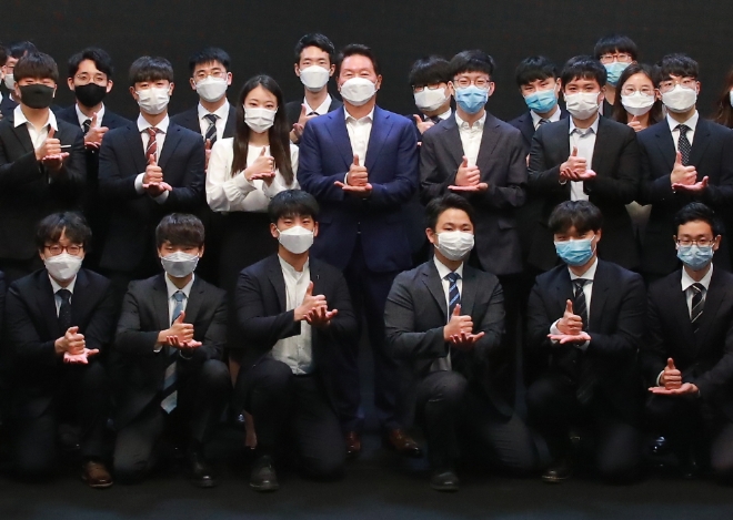 (사진=SK그룹) 7일 오후 서울 강남구 소재 한국고등교육재단에서 열린 '해외유학 장학증서 전달식'에서 최태원 SK그룹 회장(뒷줄가운데 감색 양복)과 선발된 재단 장학생들이 코로나19  극복을 위한 마음을 담아 포즈를 취하고 있다.