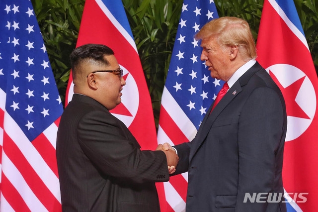 제1차 북미 정상회담이 열린 지난 2018년 6월12일 싱가포르 센토사 섬의 카펠라 호텔에서 김정은 북한 국무위원장과 도널드 트럼프 미국 대통령이 회담에 앞서 악수를 나누고 있다. (사진=싱가포르 통신정보부 제공)