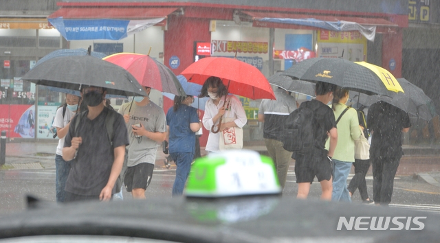 전국 곳곳에 장맛비가 내리고 있는 지난 10일 오후 울산 남구 롯데호텔 인근 횡단보도에서 시민들이 우산을 쓴 채 발걸음을 재촉하고 있다.