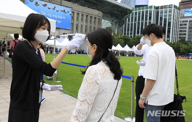 시민들이 12일 서울 중구 서울광장에 차려진 고 박원순 서울시장의 시민분향소에서 조문하기 위해 발열체크를 받고 있다.
