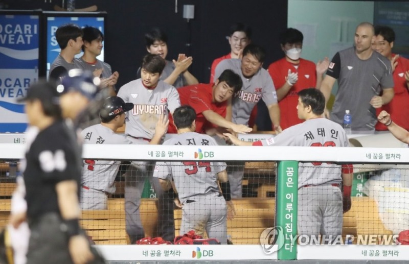 SK가 14일 두산과의 잠실경기에서 6회 초 1사 1, 2루 에서 윤석민 적시타로 홈인한 최정을 동료들이 격렬하게 환영해 주고 있다. 이날 SK는 올시즌 최다 득점하는 활화산 타력을 선보였다.