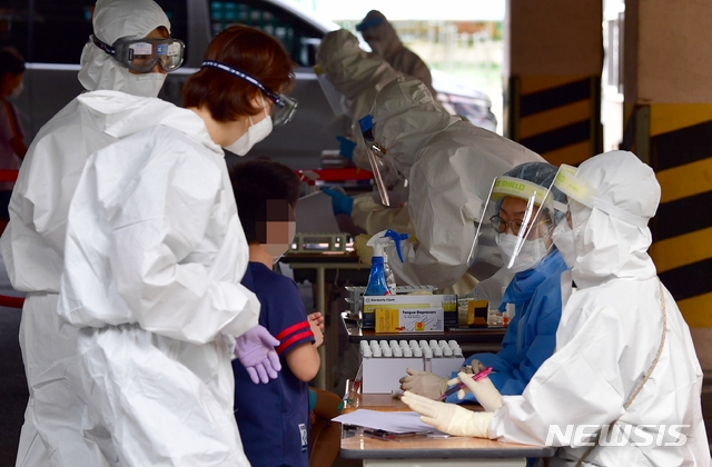 광주에서 초등생 2명이 신종 코로나바이러스 감염증(코로나19) 확진 판정을 받은 가운데 18일 오후 광주 서구 계수초등학교에 설치된 선별진료소에서 방역당국이 전 학생을 대상으로 검사를 하고 있다.