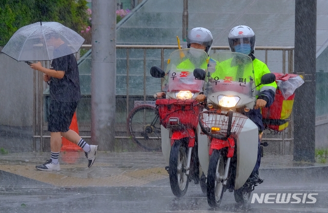 전국 곳곳에 비가 내린 지난 13일 오후 인천 서구청 근처 도로에서 우체국 집배원이 우편물 배달을 위해 빗속을 달리고 있다.