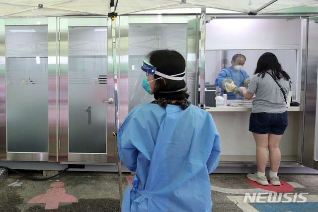 서울 강서구의 한 데이케어센터에서 20일 오전 8명이 추가 확진판정을 받아 서울에서 총 11명이 이날 추가 확진판정을 받았다. 20일 서울 강서구 보건소에 설치된 컨테이너형 워킹스루 선별진료소에서 시민들이 코로나19 검사를 받고 있다.