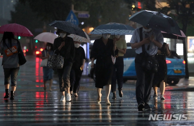 서울에 호우주의보가 발효된 지난 23일 오후 서울 종로구 광화문네거리에서 시민들이 우산을 쓰고 걸어가고 있다.