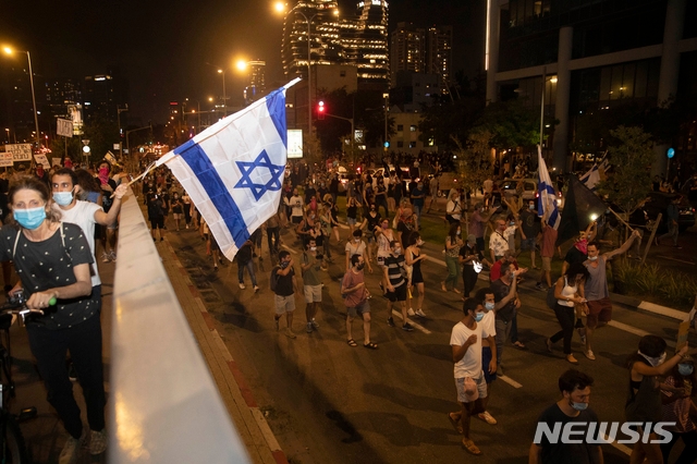 28일(현지시간) 이스라엘 텔아비브의 공안부 장관 집 부근에서 시위대가 부패척결 시위를 벌이며 행진하고 있다.
