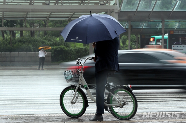전국 대부분 지역이 흐리거나 비가 내리고 있는 지난 달 20일 오전 서울 여의도환승센터에서 시민들이 우산을 쓰고 출근하고 있다.