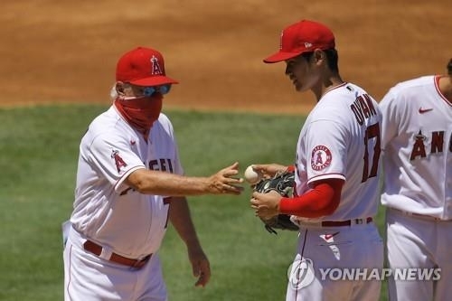 갑작스럽게 제구력 난조를 보인 오타니 쇼헤이(오른쪽)가 조 매든 감독에게 공을 건네주며 강판되고 있다.
