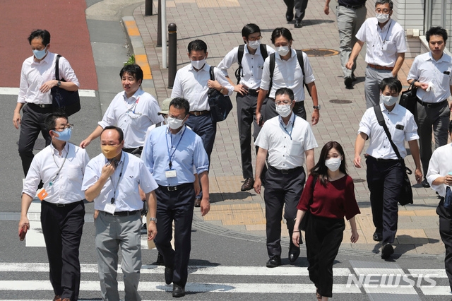 4일 일본 도쿄의 한거리를 신종 코로나바이러스 감염증(코로나19) 감염 예방을 위해 마스크를 착용한 시민들이 걷고 있다. 