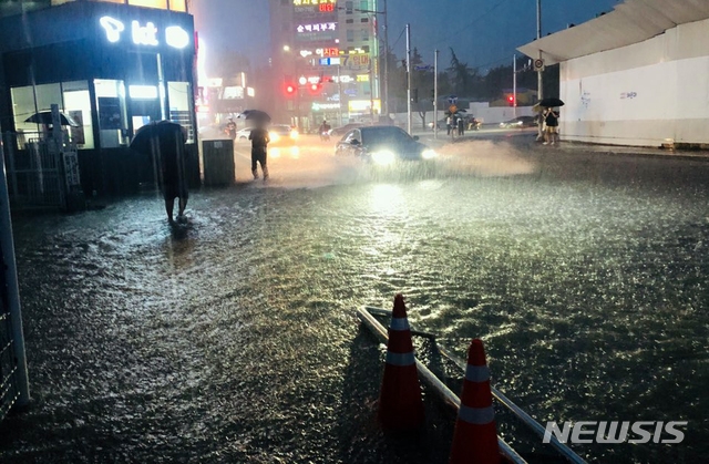 부산지역에 호우경보가 발효된 7일 오후 부산 해운대구의 한 도로가 침수돼 차량과 시민들이 힘겹게 이동하고 있다. (사진=부산경찰청 제공).