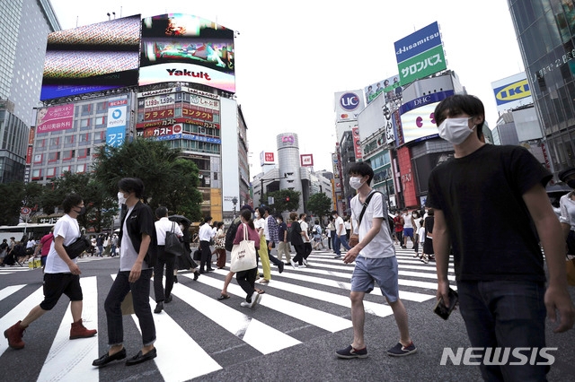 13일(현지시간) 일본 도쿄 시부야에서 코로나19 확산 예방을 위해 마스크를 쓴 사람들이 건널목을 걷고 있다.