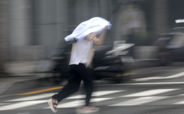 벼락과 함께 갑작스럽게 쏟아진 소나기를 피해 한 시민이 22일 서울 중구 남대문 인근 도로를 뛰어가고 있다.