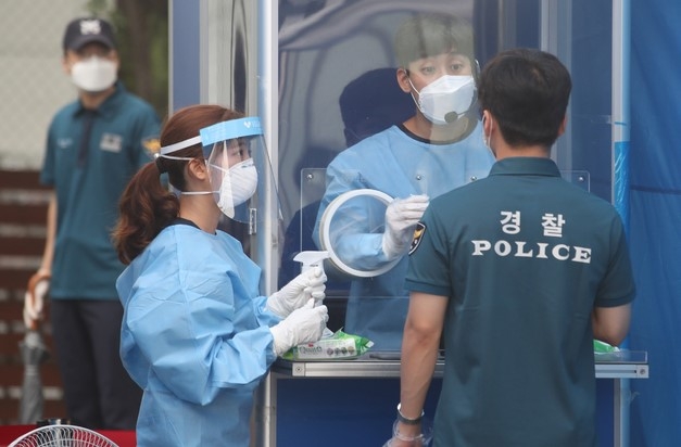 지난 21일 경찰 관계자들이 서울 중구 서울경찰청 기동본부에 마련된 선별진료소에서 신종 코로나바이러스 감염증(코로나19) 검사를 받고 있다.