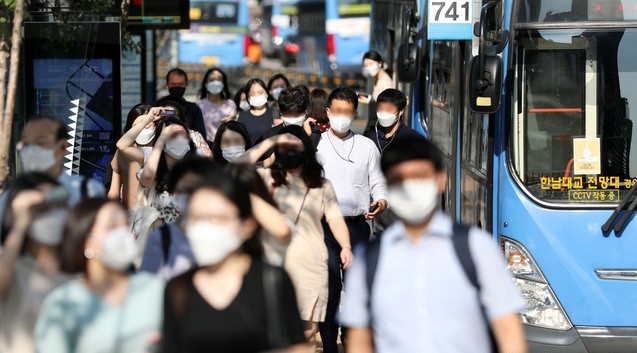 서울 전역에서 실내외 마스크 착용이 의무화된 24일 오전 서울 종로구 광화문사거리 버스정류장에서 마스크를 착용한 시민들이 출근길 발걸음을 재촉하고 있다.
