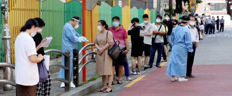 보성운수 시내버스 기사 3명이 코로나19 확진 판정을 받은 가운데 24일 오전 서울 구로구 구로구 보건소에 마련된 선별진료소를 찾은 시민들이 줄을 서 기다리고 있다.