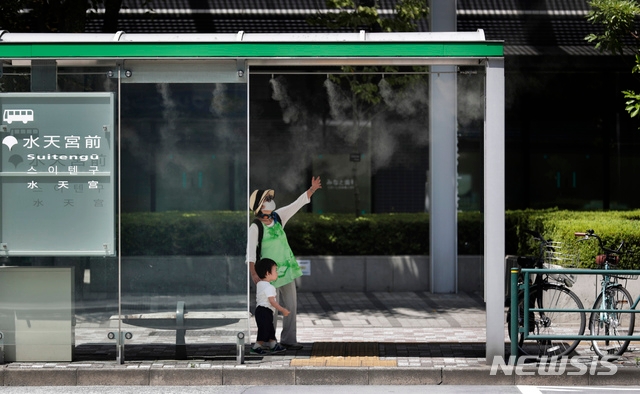 20일(현지시간) 신종 코로나바이러스 감염증(코로나19)이 확산하는 가운데 일본 도쿄의 버스 정류장에서 한 여성이 아이와 이야기하고 있다.