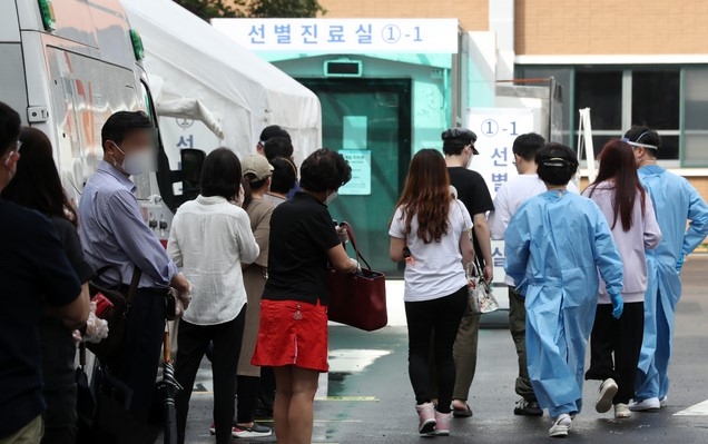 태풍 바비의 영향으로 수도권 등의 선별진료소가 임시 운영 중단됐다 다시 진료를 시작한 27일 서울 중구의 한 선별진료소를 찾은 시민이 검사를 받기 위해 줄을 서고 있다.