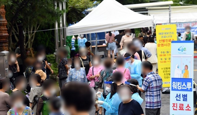 부산 해운대온천센터 직원 2명이 신종 코로나바이러스 감염증(코로나19) 확진 판정을 받으면서 방역에 비상이 걸린 가운데 해당 시설 이용자들이 28일 오전 해운대구 보건소 선별진료소로 방문, 코로나19 진단검사를 받기 위해 길게 줄을 선 채 대기하고 있다.