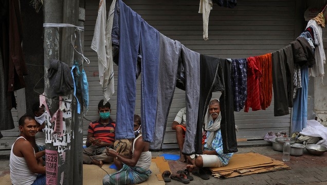 30일(현지시간) 신종 코로나바이러스 감염증(코로나19)이 퍼지고 있는 인도 뉴델리 거리에서 일용직 노동자들이 카드 놀이를 하고 있다.