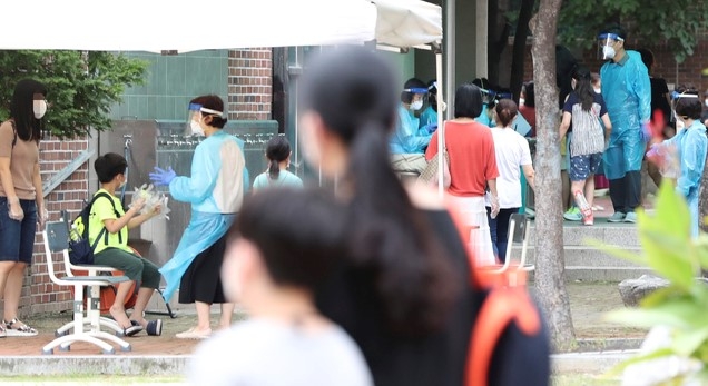 1일 신종 코로나바이러스 감염증(코로나19) 확진자가 나온 서울 중랑구 중목초등학교에 차려진 선별진료소에서 학생과 교직원 및 기타 학교관계자들이 검사를 위해 줄지어 대기하고 있다.