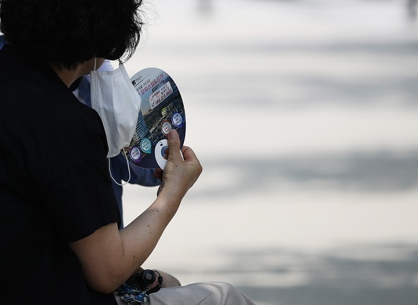 서울 낮 기온이 최고 31도를 보이는 등 무더운 날씨가 이어진 지난 8일 서울 경의선 책거리에서 한 시민이 부채질하고 있다. 〈사진=연합뉴스〉