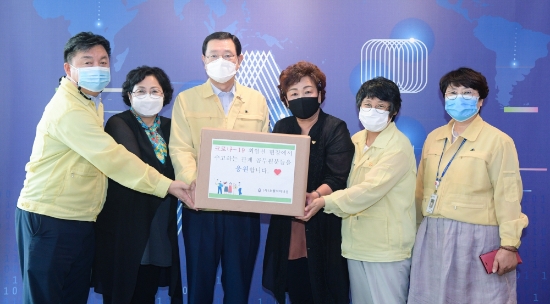 이용섭 광주광역시장이 3일 오전 시청 접견실에서 이명자 오월어머니집 관장으로부터 코로나19 방역업무 종사 공무원을 격려하기 위한 도시락을 전달 받은 뒤 기념촬영을 하고 있다./사진=광주시