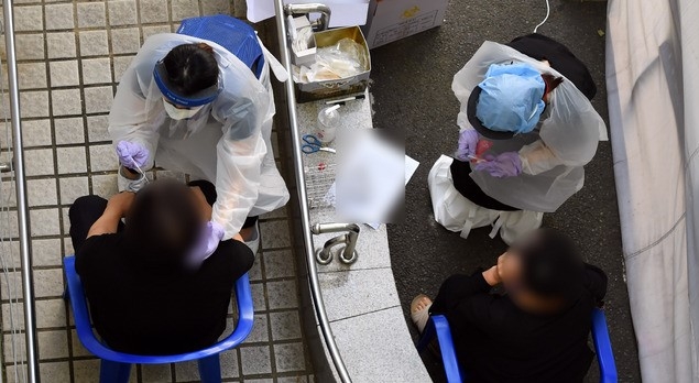 부산지역에 신종 코로나바이러스 감염증(코로나19) 확진자가 잇달아 발생하고 있는 가운데 24일 오후 부산진구 보건소 선별진료소를 찾은 시민들이 코로나19 진담검사를 위한 검체를 채취하고 있다.