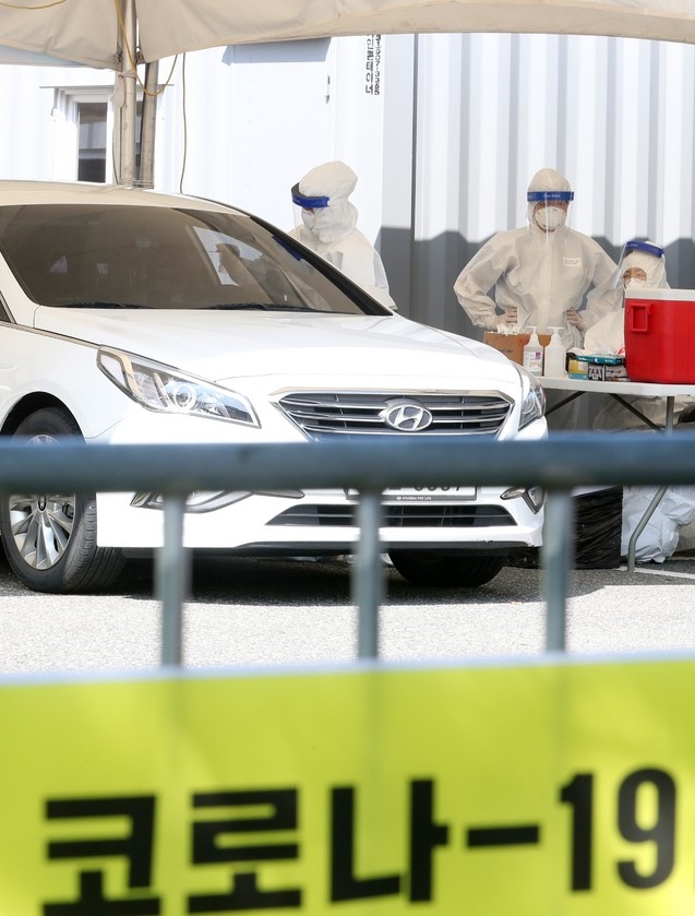 고양시가 안심카 선별진료소 재운영에 들어간 24일 오전 경기 고양시 덕양구 주교1공영주차장에 마련된 선별진료소에서 한 시민이 신종 코로나바이러스 감염증(코로나19) 감염 여부 검사를 위한 검체 채취를 받고 있다.