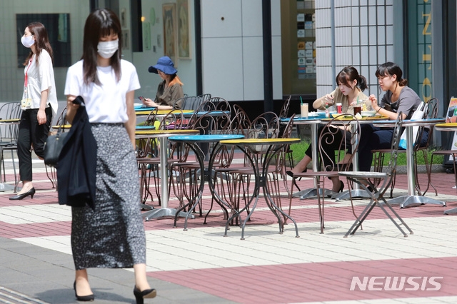 15일 일본 도쿄에서 시민들이 야외 테이블에서 마스크를 벗고 점심을 즐기고 있다.