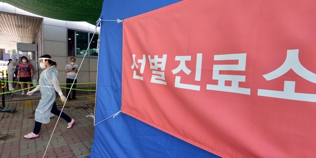 지난달 29일 대구 북구 소재 동우빌딩 지하1층에서 열린 동충하초 사업설명회가 코로나19 확산지로 지목되고 있는 가운데 4일 오전 대구 북구 침산동 북구보건소에 마련된 코로나19 선별진료소를 찾은 시민들이 검사를 받기 위해 줄을 서 있다.