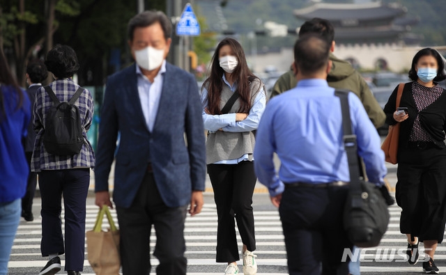 지난 21일 오전 서울 한 인도에서 긴팔 차림의 시민들이 출근길 발걸음을 옮기고 있다.