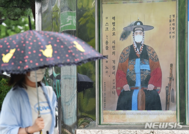 신종 코로나바이러스 감염증(코로나19) 재확산으로 수도권에서 '사회적거리두기 2.5단계'가 시행중인 7일 경기 수원시청 앞 게시판에 마스크를 쓴 정조대왕 어진이 부착돼 시민들의 눈길을 끌고 있다.