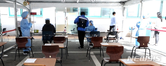 일일 신규 확진자 수가 110명을 기록하며 나흘만에 100명대로 올라선 23일 오전 서울 강남보건소 선별진료소에서 시민들이 검사를 위채 대리하고 있다.