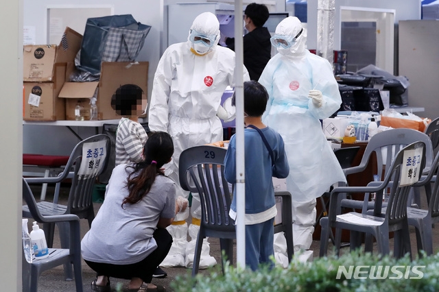 24일 오전 서울 송파구보건소에 마련된 선별진료소에서 의료진들이 신종 코로나바이러스 감염증(코로나19) 검사를 앞둔 어린이와 이야기를 나누고 있다.