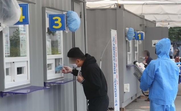 추석 연휴를 앞두고 신종 코로나바이러스 감염증(코로나19) 신규 확진자 수가 114명으로 확인된 25일 오전 서울 영등포구 영등포구보건소 선별진료소에서 한 관계자가 소독 작업을 하고 있다.
