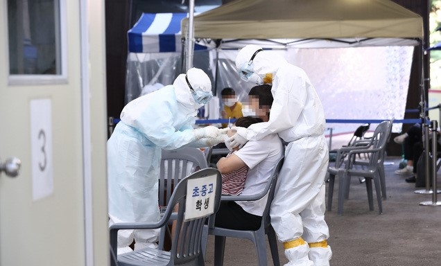 24일 오전 서울 송파구보건소에 마련된 선별진료소에서 시민들이 신종 코로나바이러스 감염증(코로나19) 검사를 받고 있다.